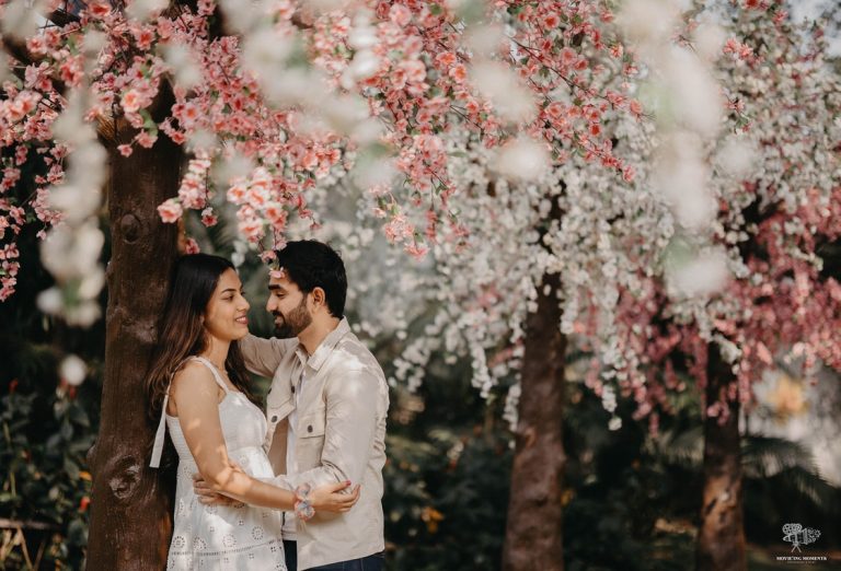 Couple standing below a cherry blossom tree